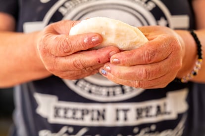 Gloria Martinez amasa una arepa de peto para el hígado encebollado de su hijo Daniel.