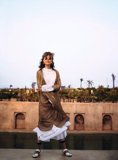 Camisa larga marrón de Hermès, vestido abullonado y pendientes de perla de Céline, gafas de sol de Kaleos, anillo de Safsafu, calcetines bordados de Cos y zapatos de piel de Stella McCartney. Para esculpir el rostro se ha utilizado la paleta de polvos bronceadores Belle de Teint Bronzer & Blush (47,50 euros), de Lancôme, que ofrece dos coloretes para cara y escote. 