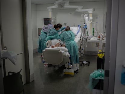 Sanitarias visitan a un enfermo ingresado en una UCI del Hospital de la Santa Creu i Sant Pau.