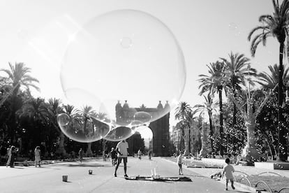 Dos niños juegan con pompas de jabón en el Arco del Triunfo (Barcelona, 2021).