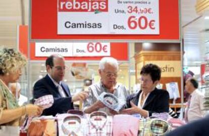 Un empleado de un centro comercial de Bilbao atiende a un matrimonio en la sección de camisería en el primer día de rebajas. EFE/Archivo