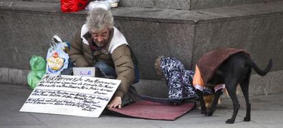 Un indigente, con dos perros, mendigando en una calle de Madrid. 