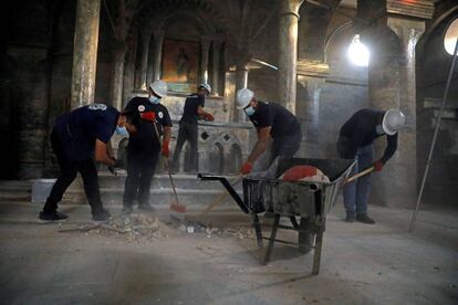 Grupo de voluntários trabalha para limpar a igreja de São Tomás em Mosul (Iraque), profanada pelo Estado Islâmico.