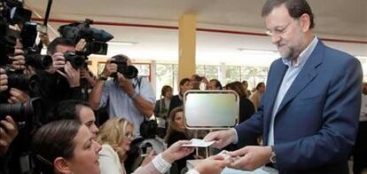 El presidente del Partido Popular, Mariano Rajoy (d), ejerce su derecho al voto para las elecciones al Parlamento Europeo en el colegio Bernardette, de Madrid.