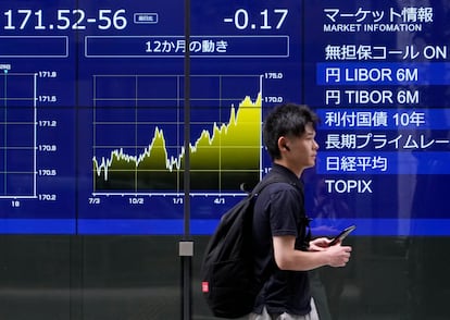 Un viandante pasa delante de un panel que indica la cotización del yen frente al dólar