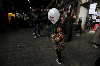 Una ni?a camina con un globo con el mensaje "Te amo", en al-Hamidiyah Soug, Damasco (Siria), el 11 de febrero de 2016.