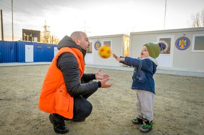 Una trabajadora humanitaria de World Vision, Catalin Romanescu, juega con Dima, de dos años, en un centro de acogida de refugiados en la frontera.