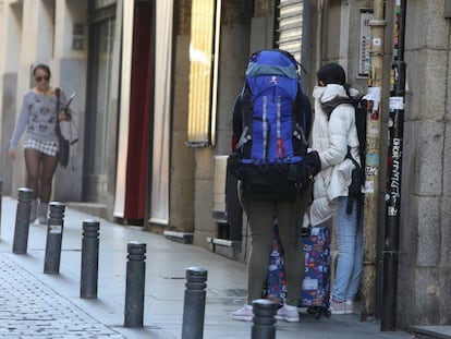 Dos turistas salen de un portal en el centro de Madrid.