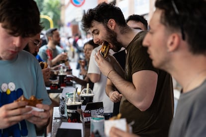 People eating hamburgers at a festival in Milan, Italy.