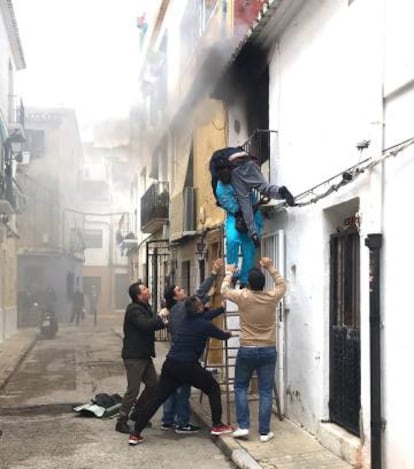 Momento en el que Gorgui Lanine, joven senegalés salva a Alex del incendio de su casa. © Roberta Etter