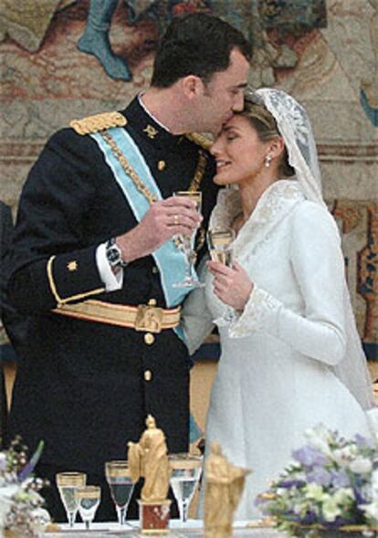 Los príncipes de Asturias, don Felipe y doña Letizia, se besan en el momento del brindis en el Palacio Real.