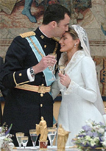 Los príncipes de Asturias, don Felipe y doña Letizia, se besan en el momento del brindis en el Palacio Real.