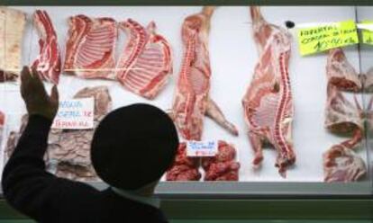 Un hombre observa el escaparate de una carnicería  en el mercado de Vitoria. EFE/Archivo