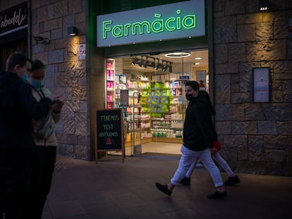 Varias personas pasan al lado de una farmacia, el 3 de enero en Barcelona.