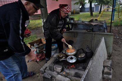 Un hombre y una mujer cocinaban el jueves en una calle en la ciudad de Izium.