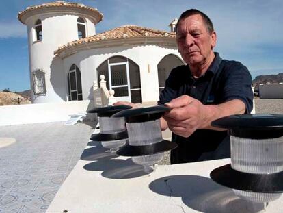 Tom, uno de los afectados, carga lámparas solares por la falta de electricidad en su vivienda.