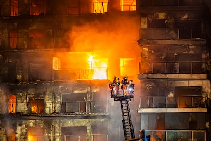 Imagen de los bomberos trabajando en la fachada del edificio de Valencia que fue devorado por las llamas.