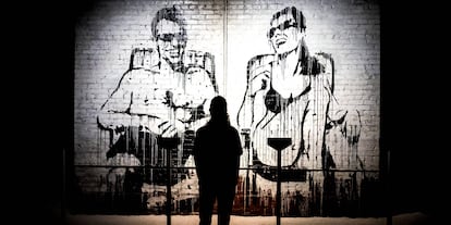 Un visitante observa un mural de un graffiti de Banksy.