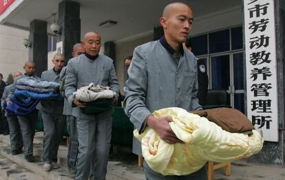 Presos del campo de trabajos forzados X&#039;ian, en la provincia de Shaanxi, hacen cola para recoger edredones en noviembre de 2006. 