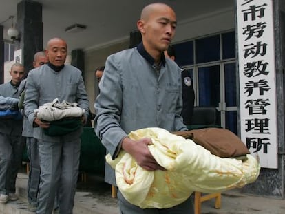 Presos del campo de trabajos forzados X&#039;ian, en la provincia de Shaanxi, hacen cola para recoger edredones en noviembre de 2006. 