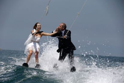 Una pareja realiza esquí acuático vestidos con sus trajes de bodas, al norte de Beirut (Líbano).