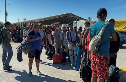 Migrantes que formaron parte de una caravana hacen fila para abordar un autobús con destino a diferentes ciudades, en Tehuantepec, México, el 24 de noviembre de 2024.