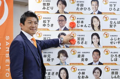 El líder del ultraderechista Sanseito, Sohei Kamiya, coloca una flor artificial para indicar los candidatos de su partido victoriosos en las elecciones al Senado japonés, el pasado domingo. 