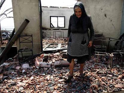 Una mujer pasea entre las ruinas de su casa en el pueblo de Artemisa, uno de los más dañados por el incendio.