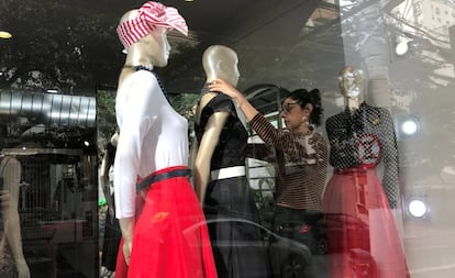 Una mujer cambia el vestuario de maniquíes en una tienda de Sao Paulo.