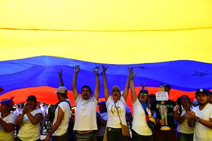 Seguidores del presidente interino, Juan Guaidó, portan una enorme bandera durante las movilizaciones en Caracas.
