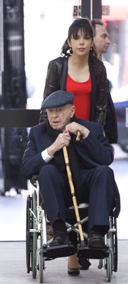 Alfredo di Stéfano in a wheelchair being pushed by his girlfriend.