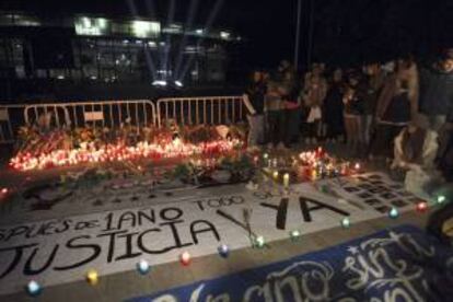 Familiares, amigos y conocidos de las cinco jóvenes muertas en la tragedia del Madrid Arena hace un año, rezan durante la vigilia celebrada junto al pabellón para recordar a las víctimas.