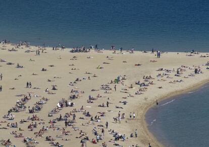 Ba&ntilde;istas en la playa de la Barceloneta, en Barcelona, al inicio del periodo vacacional de Semana Santa. 