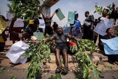 Una mujer golpea ramas en el suelo mientras ella y otros manifestantes acusan a la comisión electoral de irregularidades y privación de derechos a los votantes, en Abuya, Nigeria, este martes.