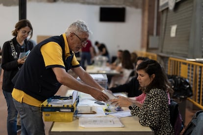 Un cartero entrega el voto por correo a un miembro de una mesa electoral en Barcelona, este domingo. 