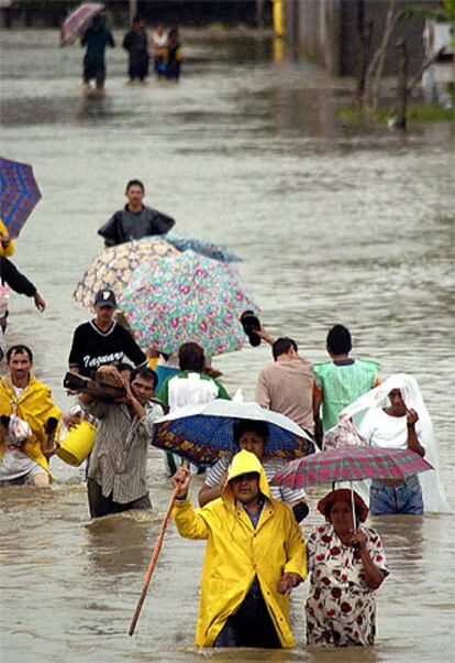 Ciudadanos hondureños atraviesan una calle inundada en una colonia popular de la ciudad de San Pedro Sula, al norte de la ciudad de Tegucigalpa.