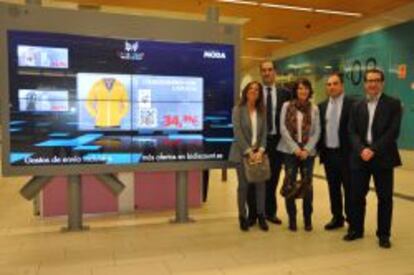 Cristina Mart&iacute;n, Alberto Mingo, Sandra Cerqueira, Enrique Uviedo y Luis Nieto, los cinco fundadores de Bidiscount, junto a una pantalla inteligente en el intercambiador de Moncloa, en Madrid.