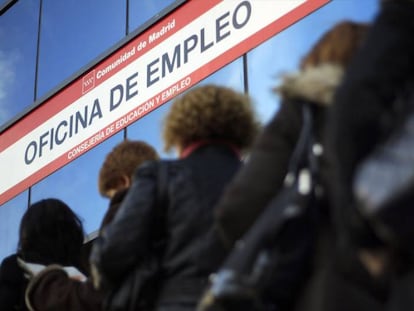 Mujeres esperan ante una oficina de empleo.