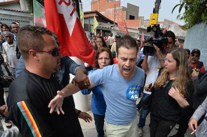 Um partidário do candidato Aécio Neves é contido no mesmo colégio eleitoral em que o ex-presidente Lula votava, em São Bernardo do Campo.