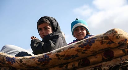 Niños desplazados de la ciudad de Afrin, de mayoría kurda, en el norte de Siria, que está casi rodeada por fuerzas dirigidas por turcos, llegan a la aldea de Anab, unos kilómetros al este, en la provincia norteña de Alepo, el 14 de marzo de 2018.