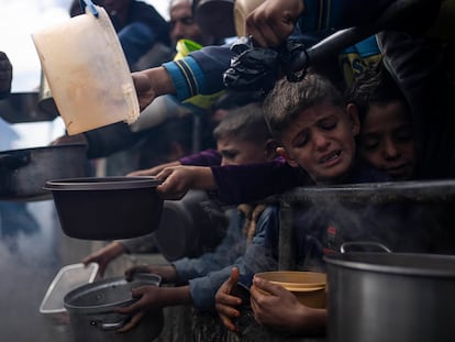 Palestinian children wait to receive food made at a charity kitchen amid food shortages, in Rafah, Feb. 16.