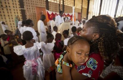 Un nen dorm en braços de la seva mare durant la missa en una església de Garissa aquest diumenge.