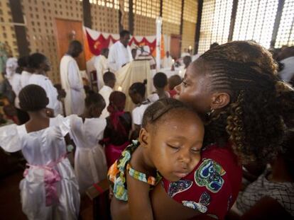 Un nen dorm en braços de la seva mare durant la missa en una església de Garissa aquest diumenge.