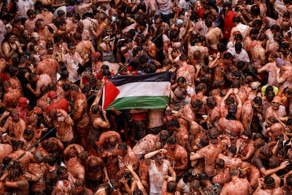 Varios participantes extienden una bandera de Palestina durante la celebración.