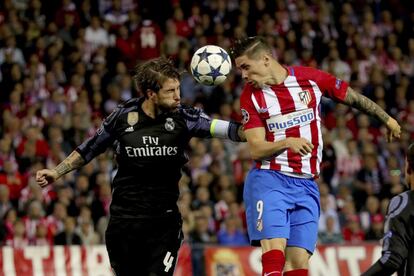 El defensa del Real Madrid Sergio Ramos (i) salta por el balón con Fernando Torres, del Atlético de Madrid.