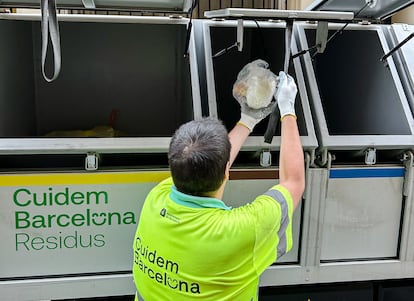 Un trabajador de la limpieza de Barcelona arroja residuos orgánicos en el depósito correspondiente del camión.