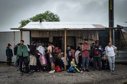 Decenas de migrantes se resguardan de la lluvia luego de ser retenidos en la estación migratoria Siglo XXI de Tapachula, Chiapas