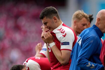 El jugador danés Jonas Wind llora mientras los sanitarios practicaban maniobras de reanimación sobre el mismo césped.
