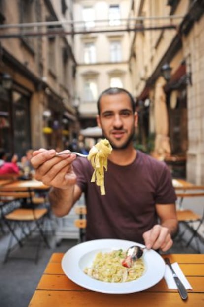 Un joven come un plato de 'tagliatelle' en un restaurante romano.