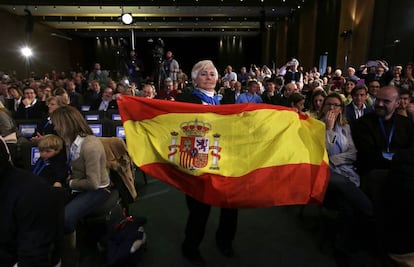 Una mujer despliega una bandera de Espa&ntilde;a en un acto de Rajoy este domingo en Barcelona.